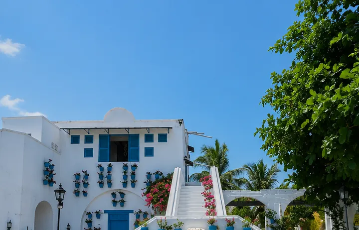 Casas blancas con puertas azules y flores en la Aldea Plaza Santorini.