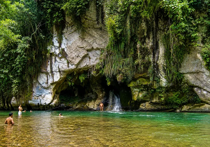 Paredes de roca y pequeñas cascadas sobre el río, rodeadas de selva.