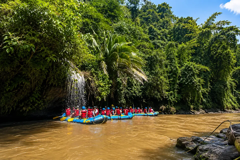 Un grupo navegando en balsa por el Río Claro, entre la selva y las paredes de roca del cañón.
