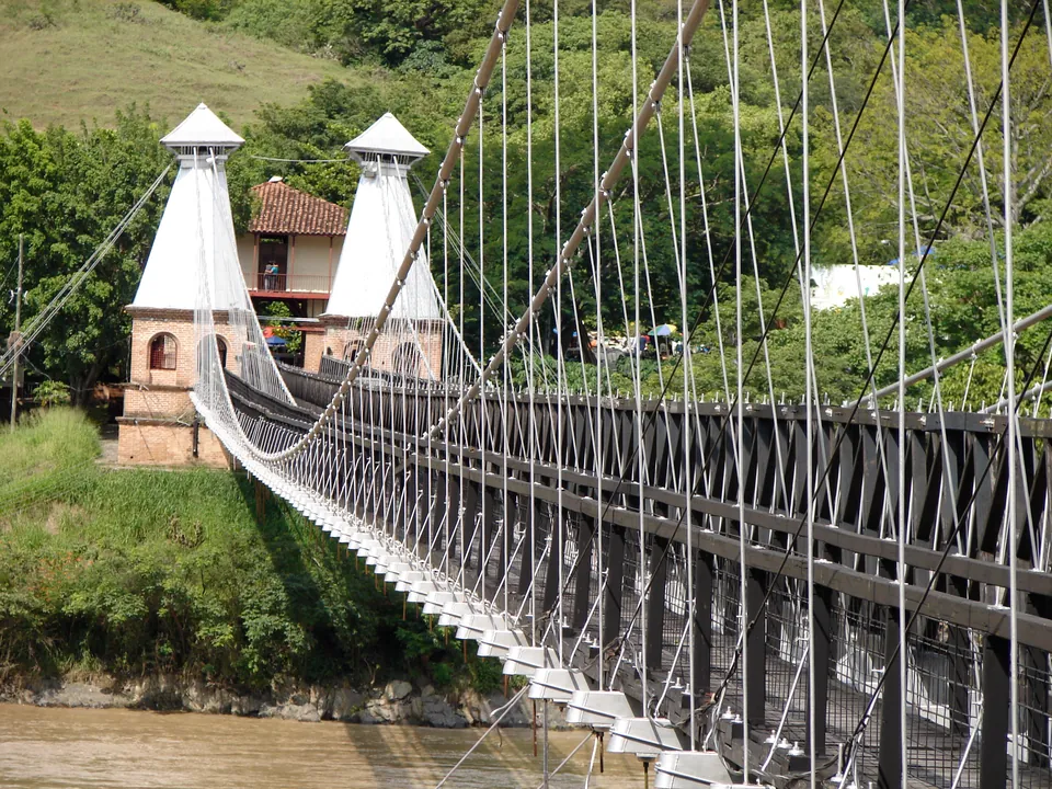 El Puente de Occidente sobre el río Cauca, con su estructura colgante de hierro y sus cables tendidos entre las torres.