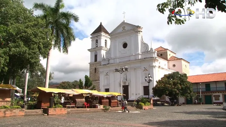 El parque principal de Santa Fe de Antioquia, con su iglesia blanca al fondo y palmeras alrededor.